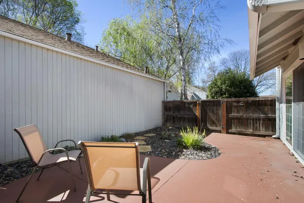a view of a chairs and table in the back yard of the house