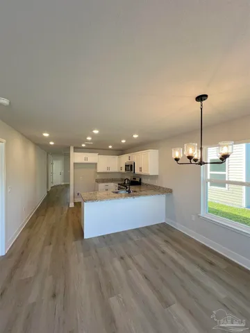 a large kitchen with stainless steel appliances kitchen island a large counter top and a wooden floors