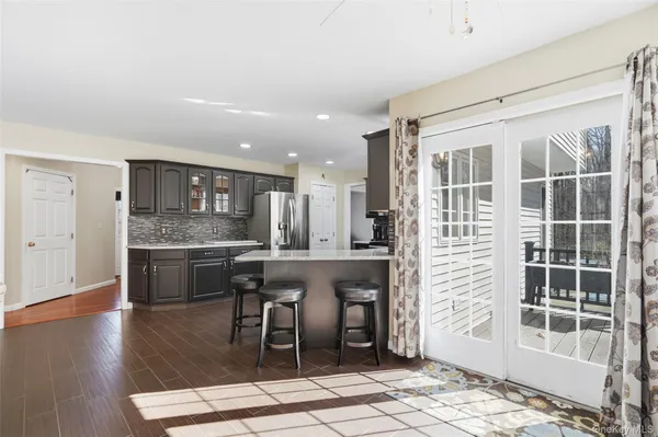 a dining room with a table chairs and kitchen view