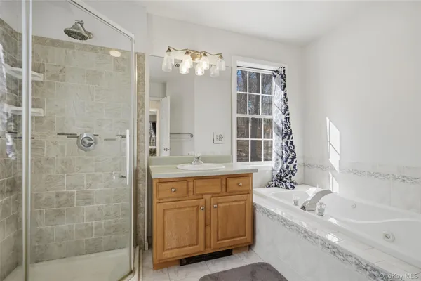 a bathroom with a granite countertop sink a large mirror and a bathtub