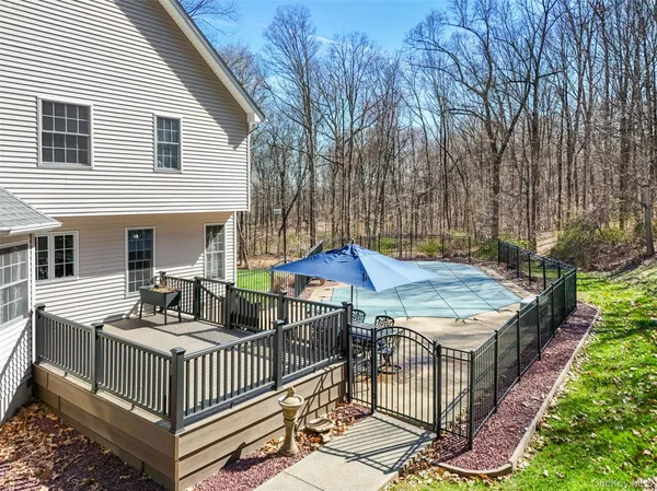 a view of a house with wooden deck and furniture
