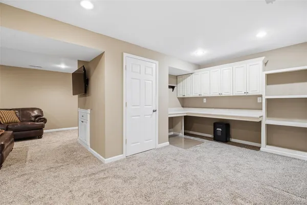 a view of kitchen with cabinets and window