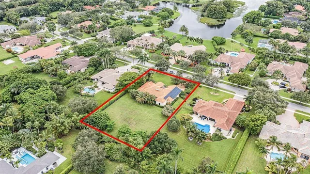 an aerial view of a house with a yard and lake