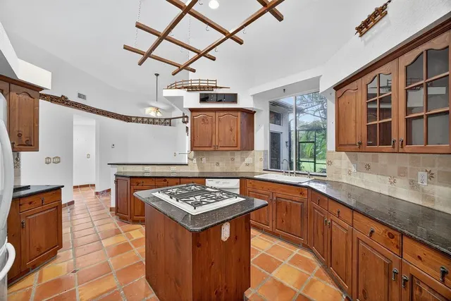 a kitchen with stainless steel appliances granite countertop a sink stove and cabinets