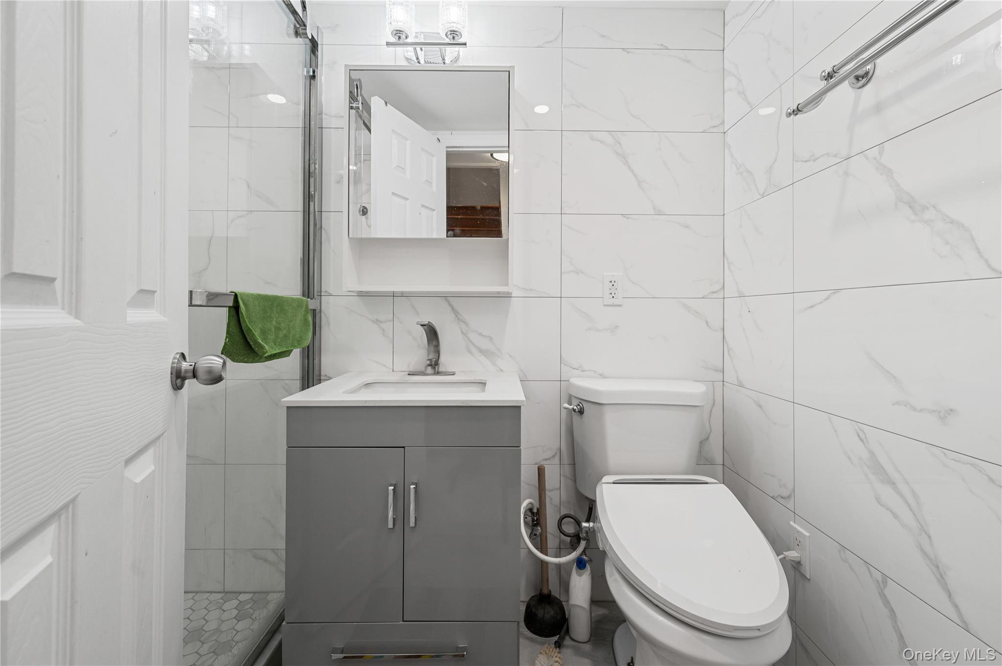 152-10 Peck Avenue Queens, NY 11355 - Photo 18 of 26 Bathroom with vanity and tile walls