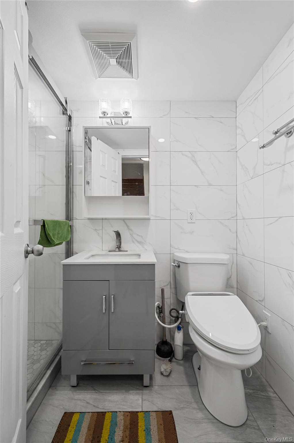 152-10 Peck Avenue Queens, NY 11355 - Photo 19 of 26 Bathroom with tile walls, vanity, a stall shower, and light marble finish flooring