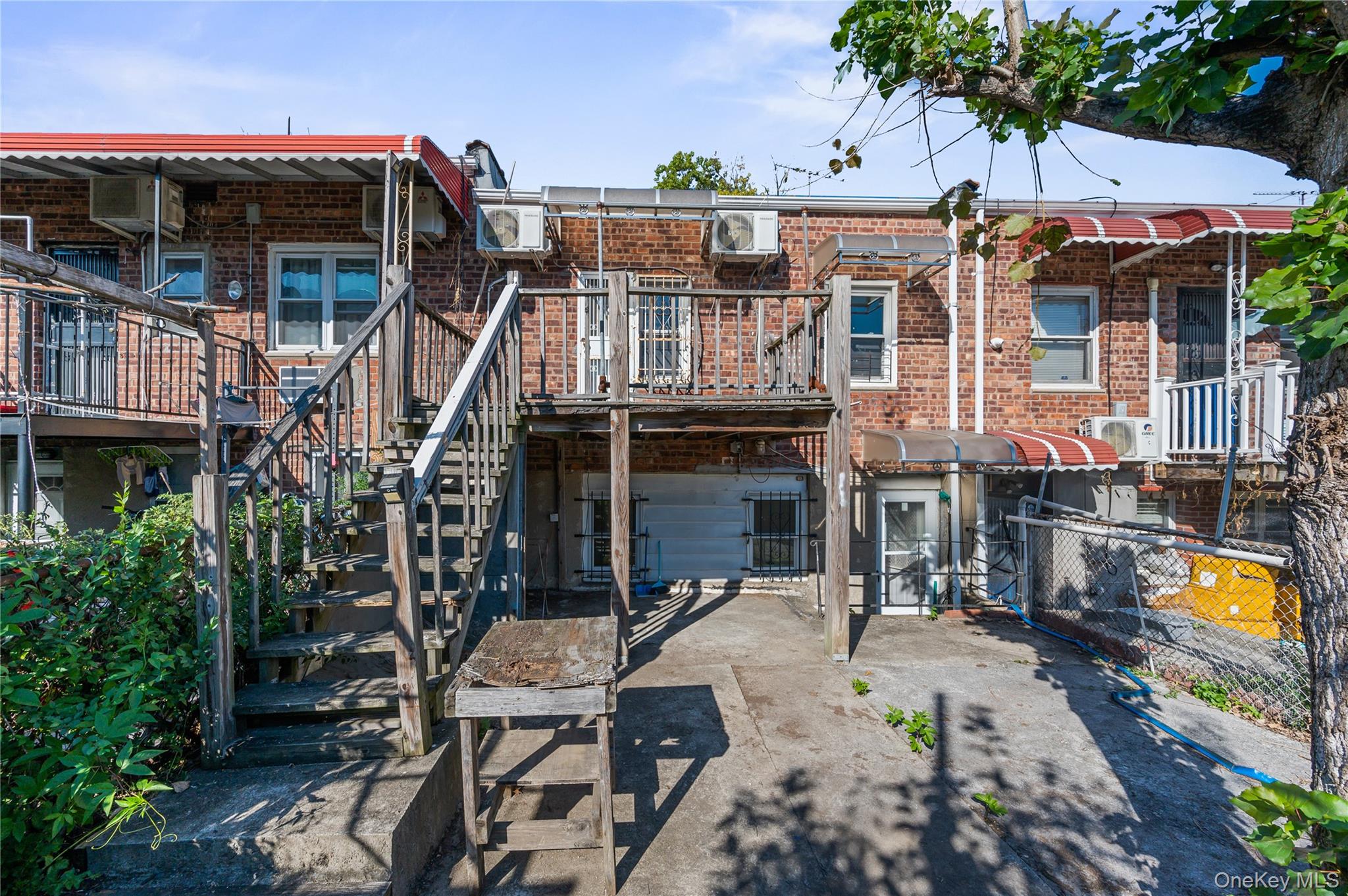 152-10 Peck Avenue Queens, NY 11355 - Photo 26 of 26 Back of property featuring brick siding, a deck, stairs, and a patio