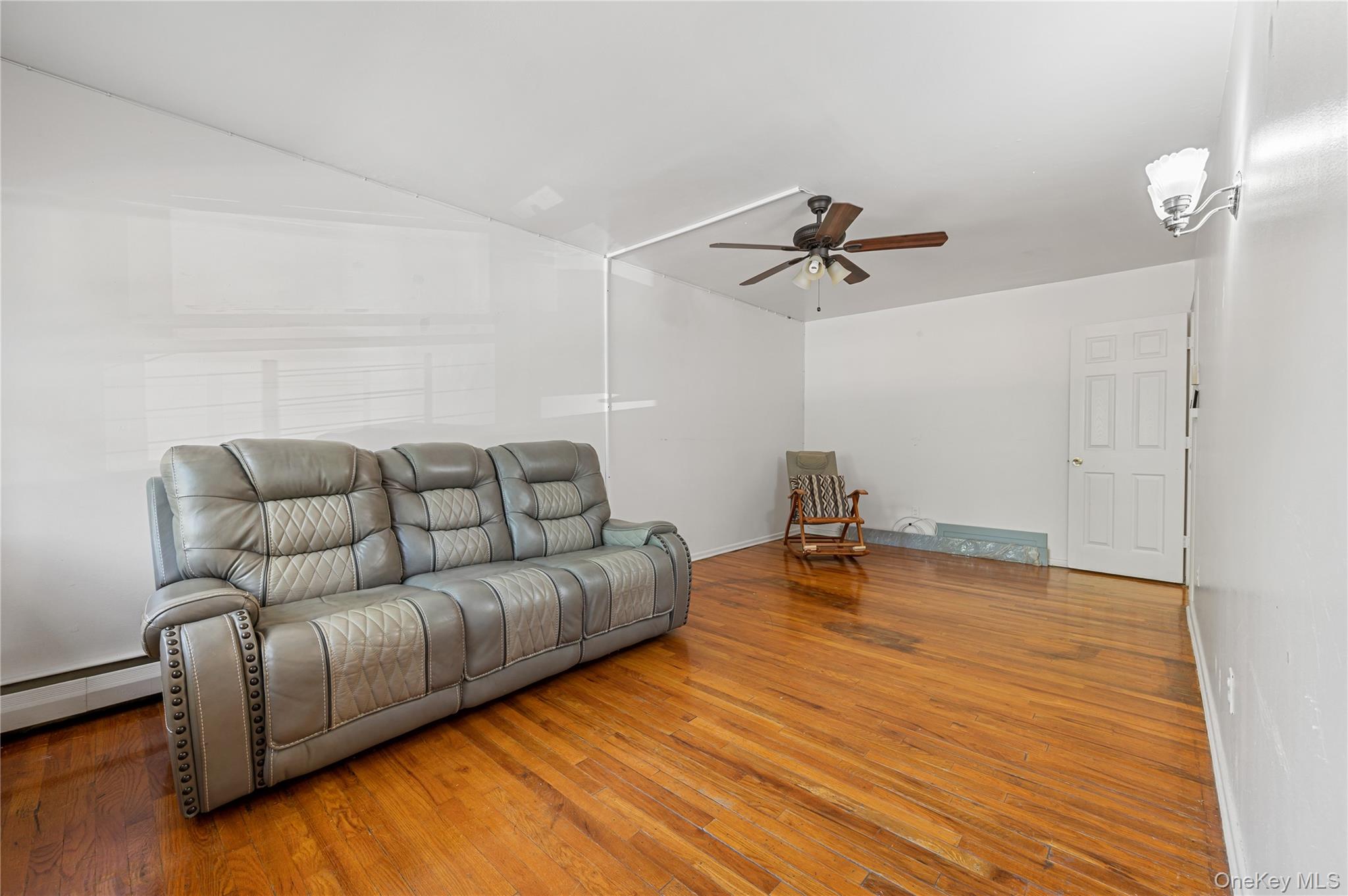 152-10 Peck Avenue Queens, NY 11355 - Photo 4 of 26 Living area with hardwood / wood-style floors, a ceiling fan, and baseboard heating