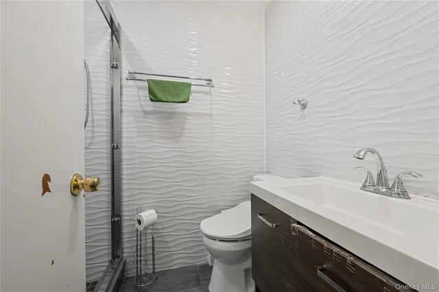 a bathroom with a toilet a sink and mirror