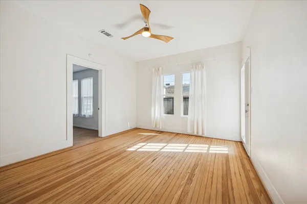 a view of an empty room with wooden floor
