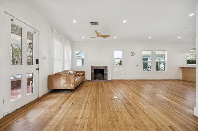 a living room with a couch wooden floor and a fireplace