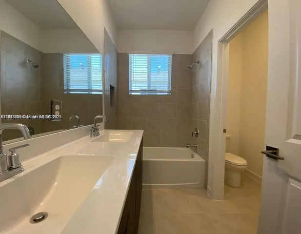 a bathroom with a tub a sink and a large mirror