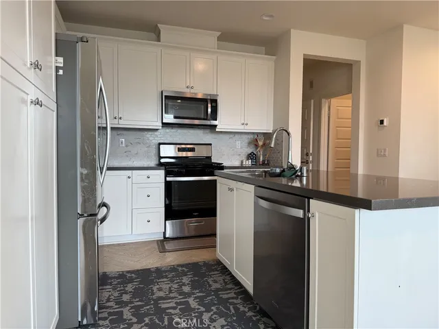 a kitchen with stainless steel appliances a refrigerator stove and sink