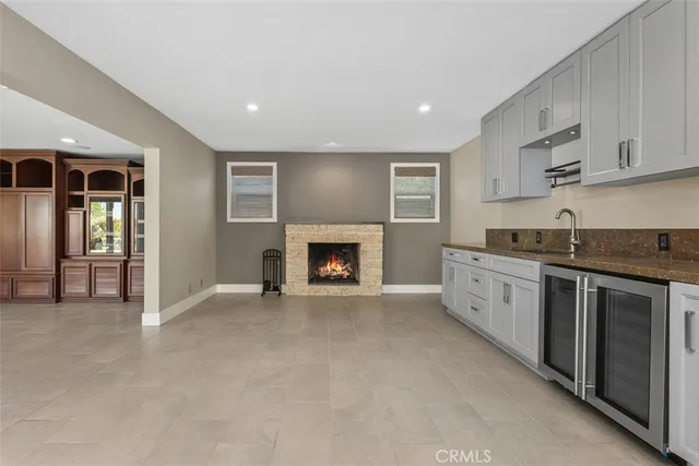 a view of n empty room with window and a kitchen
