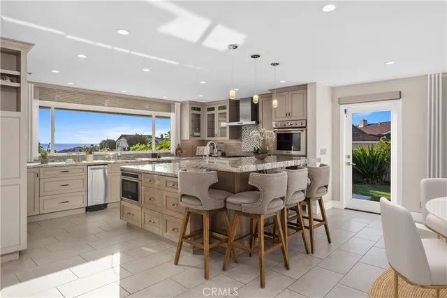 a large kitchen with stainless steel appliances granite countertop a sink stove and cabinets