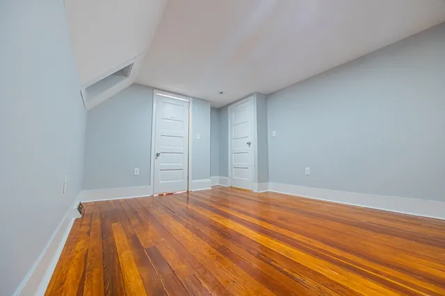 a bedroom with a bed and a wooden floor