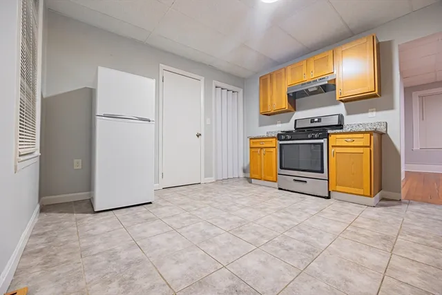 a view of kitchen with stainless steel appliances granite countertop a stove top oven a sink and a refrigerator