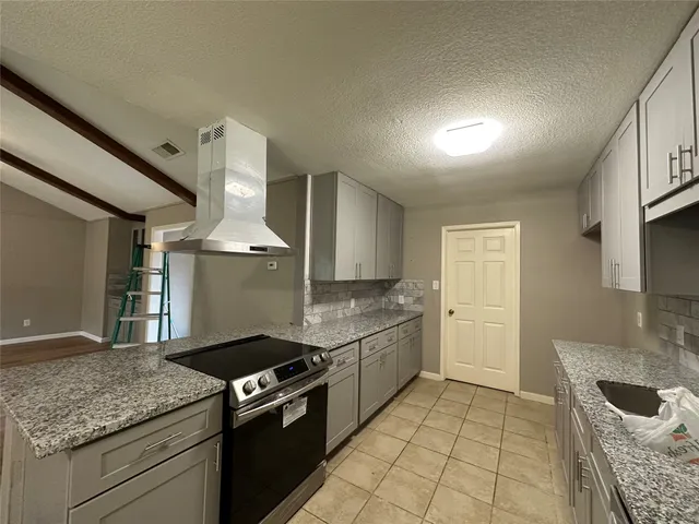 a kitchen with granite countertop a sink and a stove