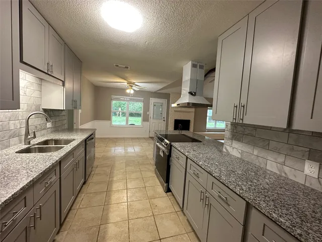a large kitchen with stainless steel appliances granite countertop a sink stove and cabinets