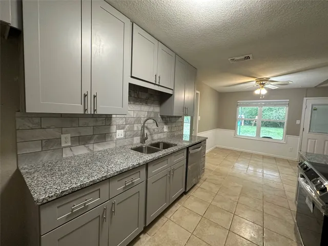 a kitchen with stainless steel appliances granite countertop a sink stove and cabinets