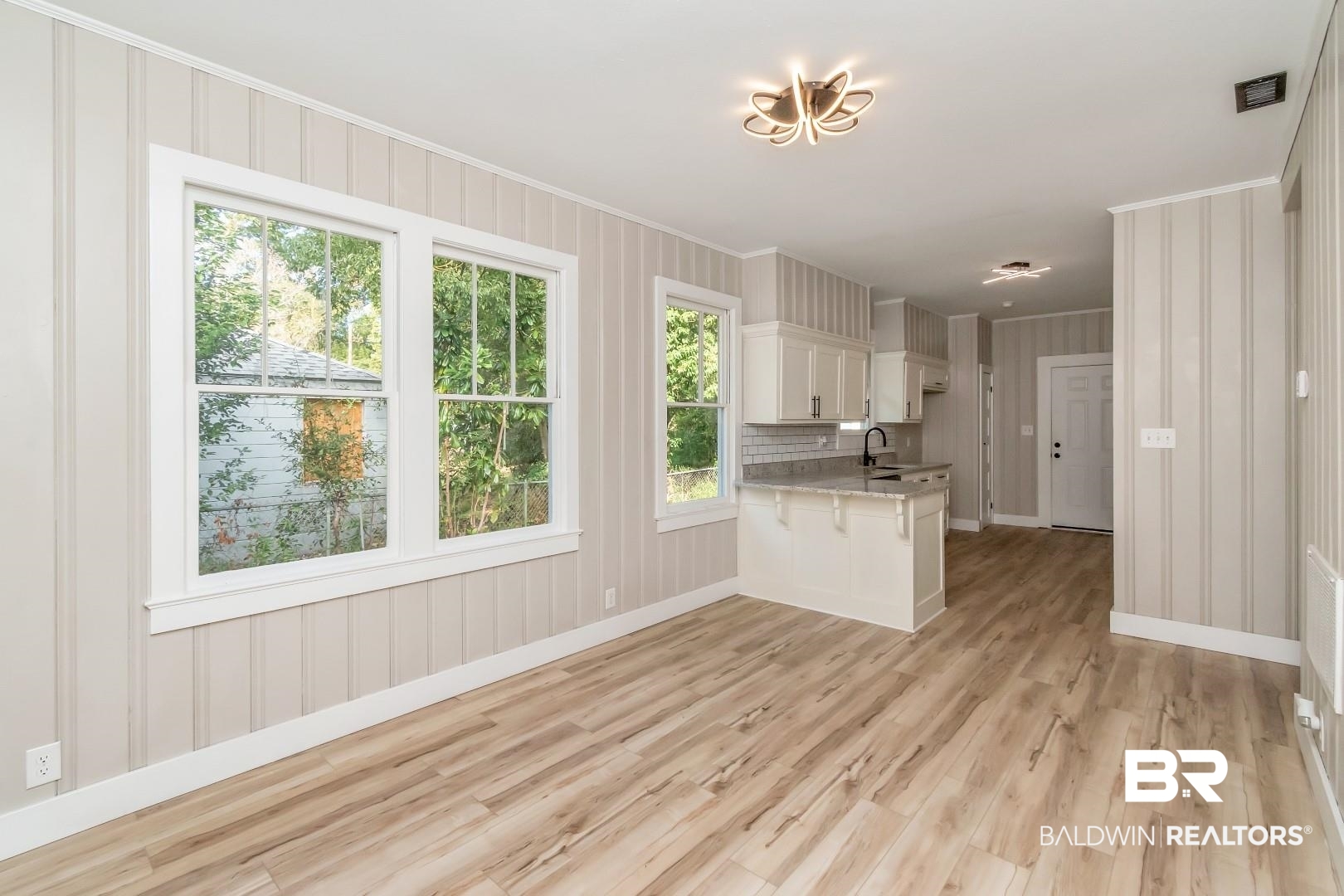 555 Michigan Avenue Mobile, AL 36604 - Photo 10 of 28 Kitchen with light wood-type flooring, white cabinetry, a kitchen breakfast bar, and plenty of natural light
