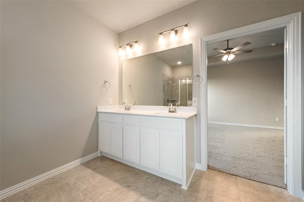 1230 County Road 200 Valley View, TX 76272 - Photo 18 of 26 Full bathroom featuring double vanity, a stall shower, ceiling fan, and light colored carpet