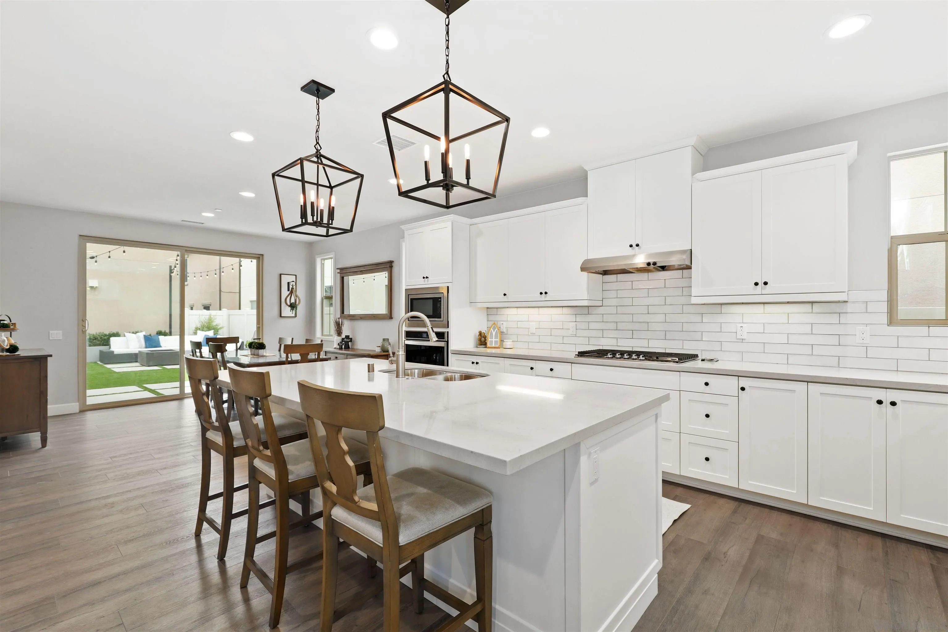 655 Gemstone Drive San Marcos, CA 92078 - Photo 10 of 48 a kitchen with a dining table chairs cabinets and stainless steel appliances
