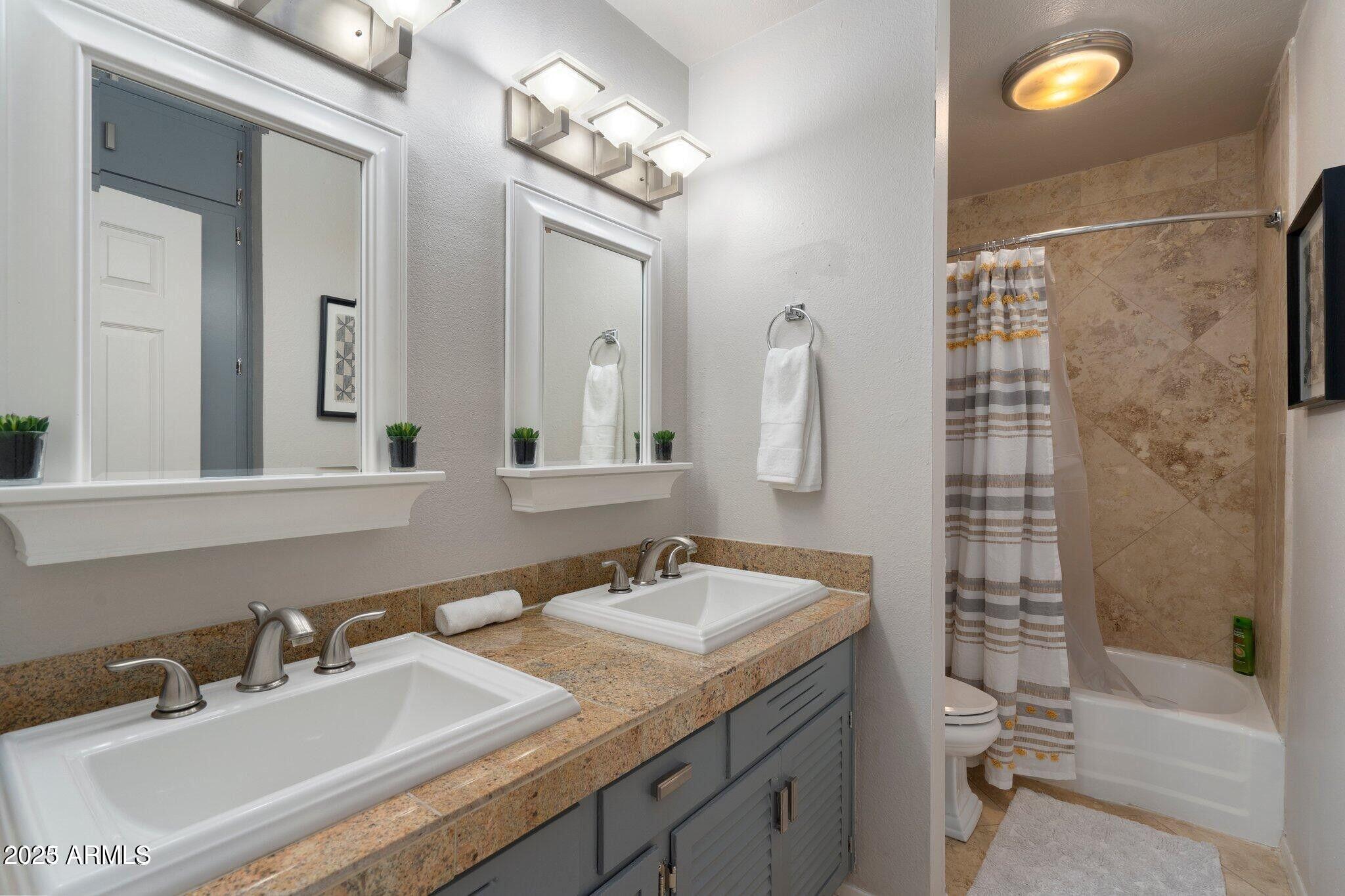 6501 North 17th Avenue, Unit 101 Phoenix, AZ 85015 - Photo 21 of 27 a bathroom with a sink double vanity granite tub and a mirror