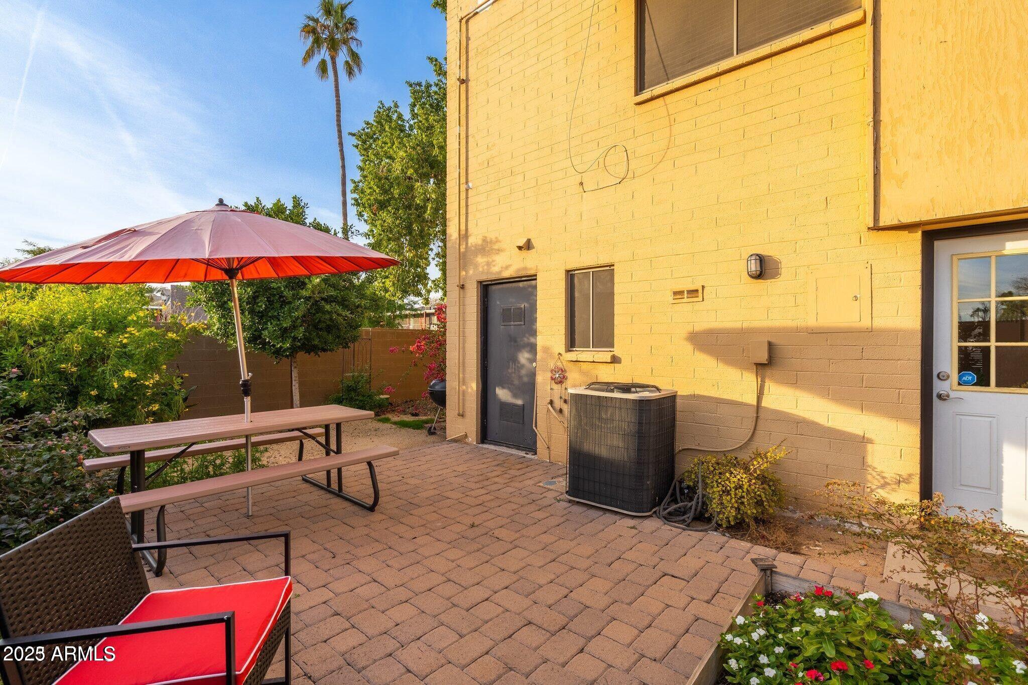 6501 North 17th Avenue, Unit 101 Phoenix, AZ 85015 - Photo 22 of 27 a view of a patio with a table and chairs under an umbrella