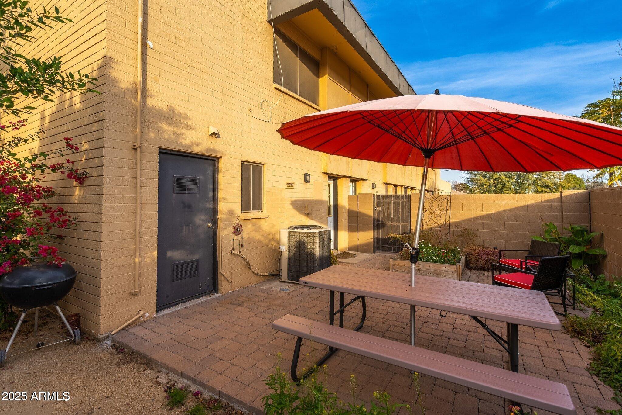 6501 North 17th Avenue, Unit 101 Phoenix, AZ 85015 - Photo 23 of 27 a view of a patio with table and chairs under an umbrella
