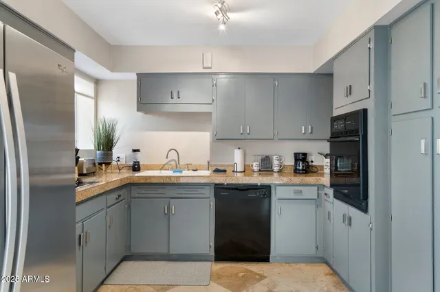 a kitchen with stainless steel appliances a sink stove refrigerator and cabinets