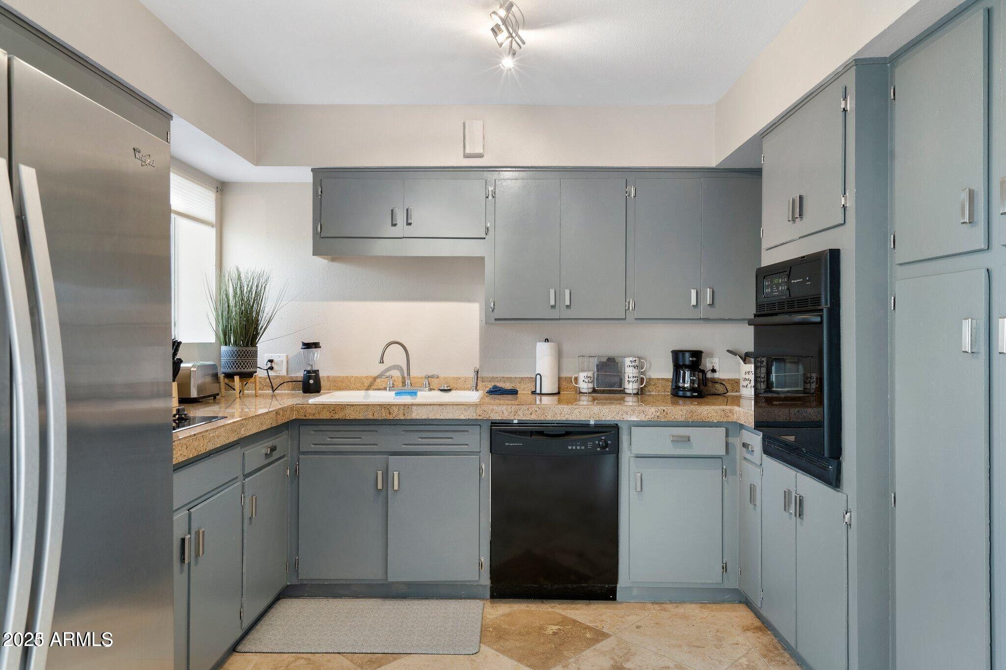6501 North 17th Avenue, Unit 101 Phoenix, AZ 85015 - Photo 7 of 27 a kitchen with stainless steel appliances a sink stove refrigerator and cabinets