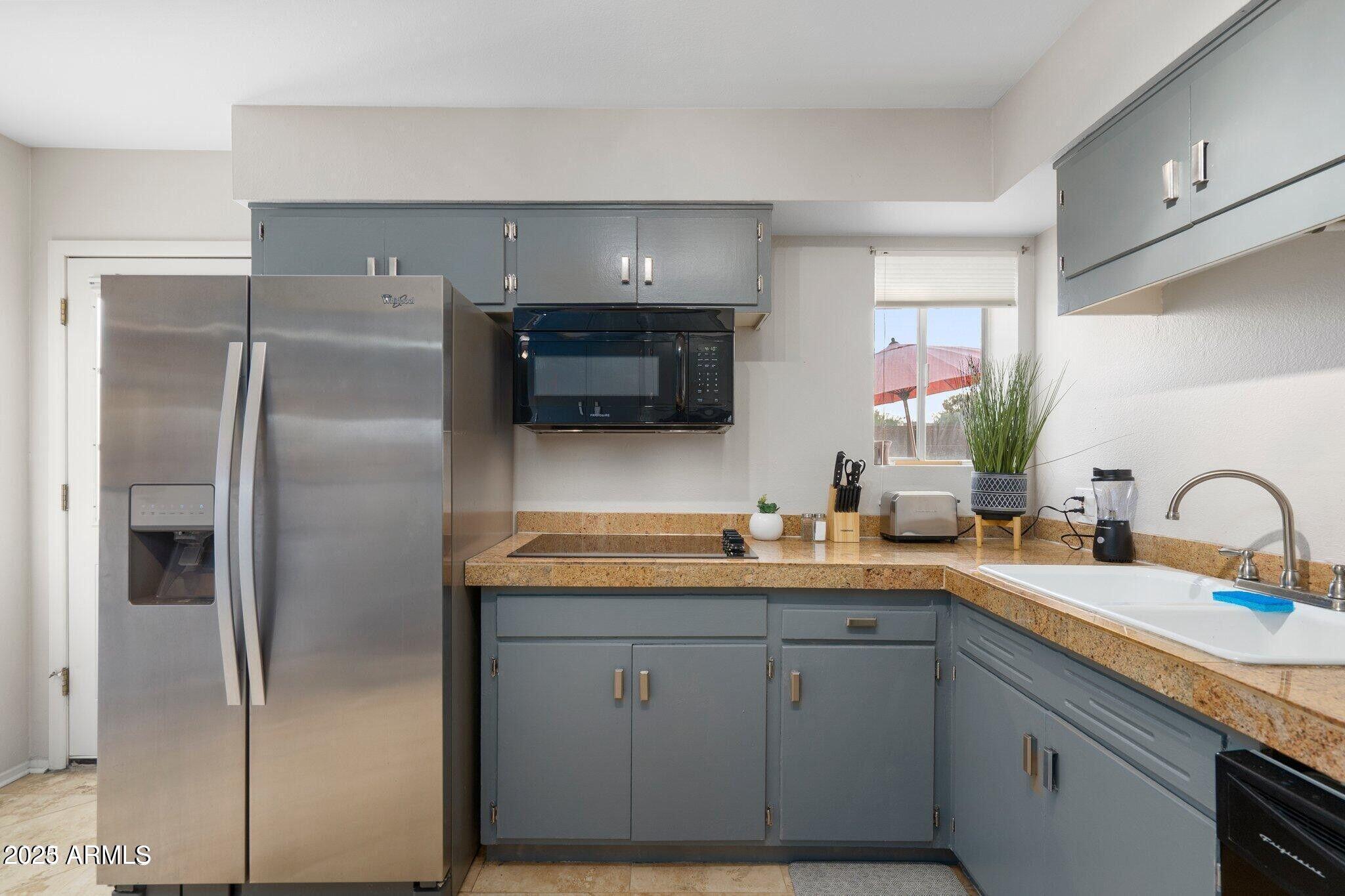6501 North 17th Avenue, Unit 101 Phoenix, AZ 85015 - Photo 8 of 27 a kitchen with a sink refrigerator and cabinets