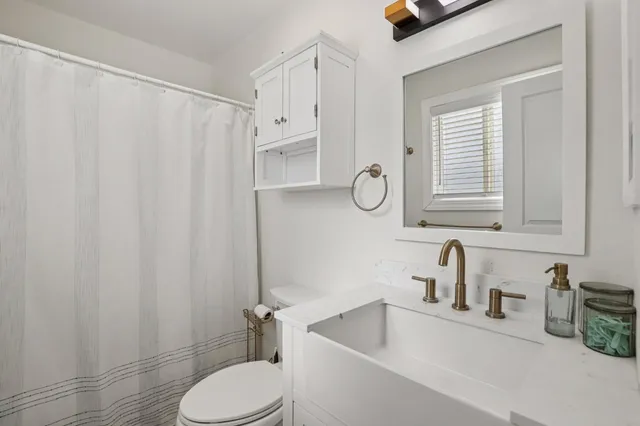 a bathroom with a sink toilet and shower