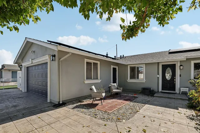a backyard of a house with table and chairs