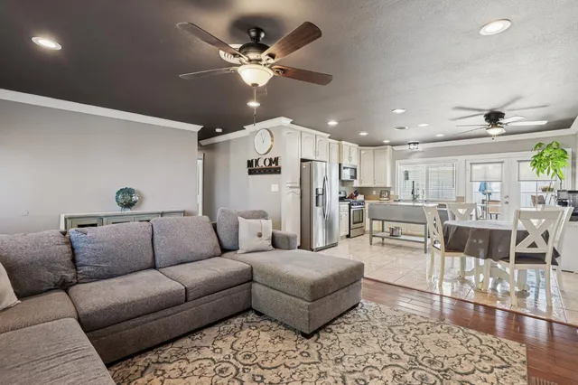 a living room with furniture kitchen view and a chandelier