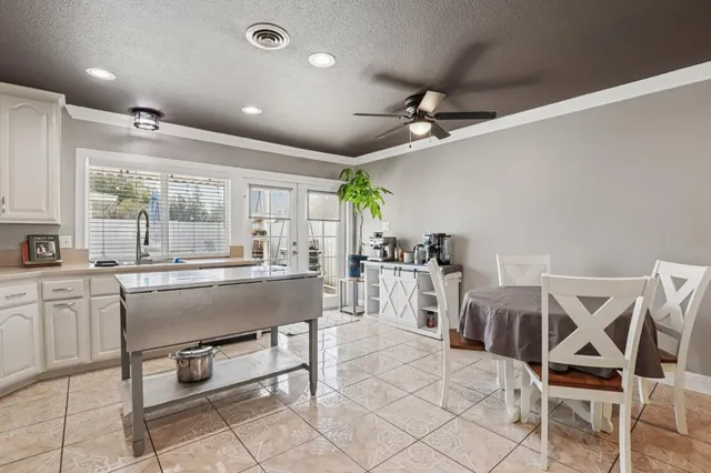 a dining hall with stainless steel appliances kitchen island granite countertop a dining table chairs and granite counter tops