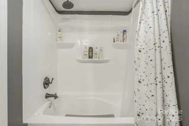 a bathroom with a bathtub and a shower curtain