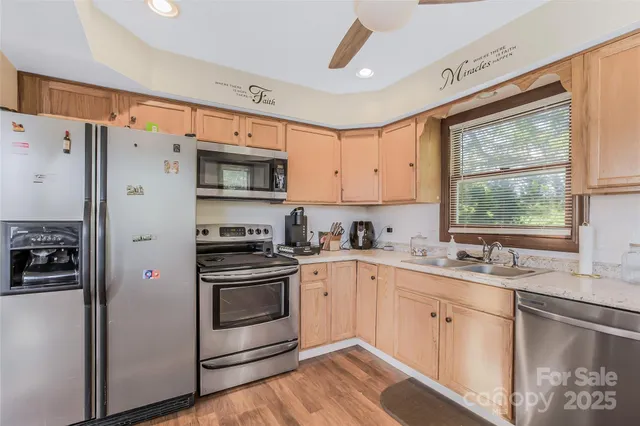 a kitchen with a sink a window and stainless steel appliances