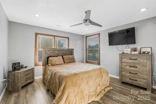 a bedroom with a bed a flat screen tv and dresser