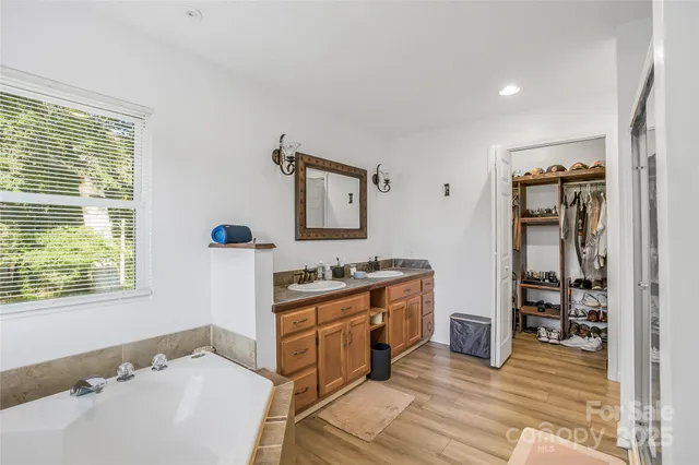 a spacious bathroom with a tub sink and mirror