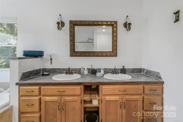 a bathroom with a granite countertop sink and a mirror