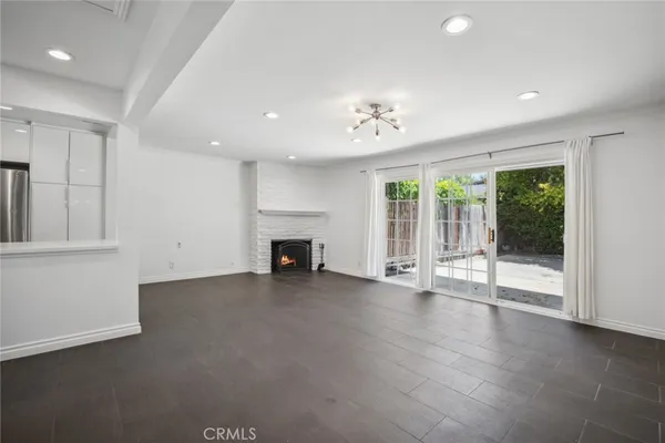 a view of an empty room with a fireplace and a window