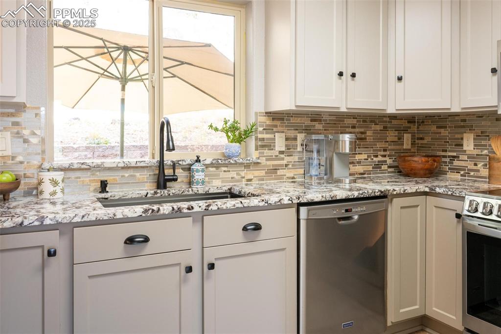 320 Hilton Road Manitou Springs, CO 80829 - Photo 12 of 44 a kitchen with stainless steel appliances granite countertop a sink and a white cabinets