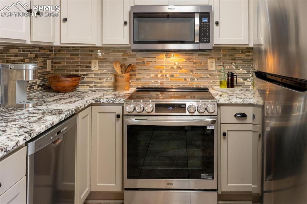 320 Hilton Road Manitou Springs, CO 80829 - Photo 13 of 44 a kitchen with stainless steel appliances granite countertop a stove microwave and sink