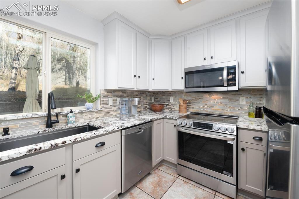 320 Hilton Road Manitou Springs, CO 80829 - Photo 10 of 44 a kitchen with cabinets stainless steel appliances a sink and a window
