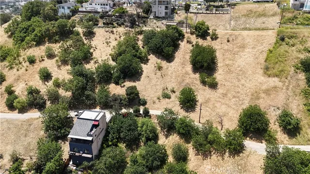 an aerial view of residential house with outdoor space and trees all around