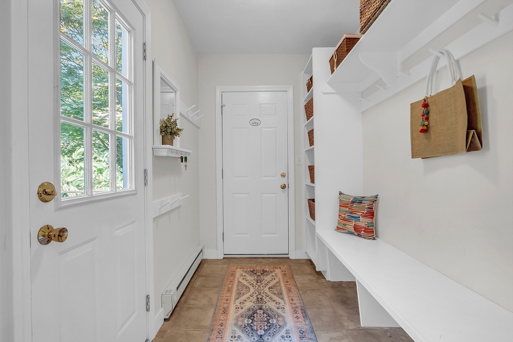 9 Berry Lane Acton, MA 01720 - Photo 11 of 42 a hallway with painting on the wall and a window