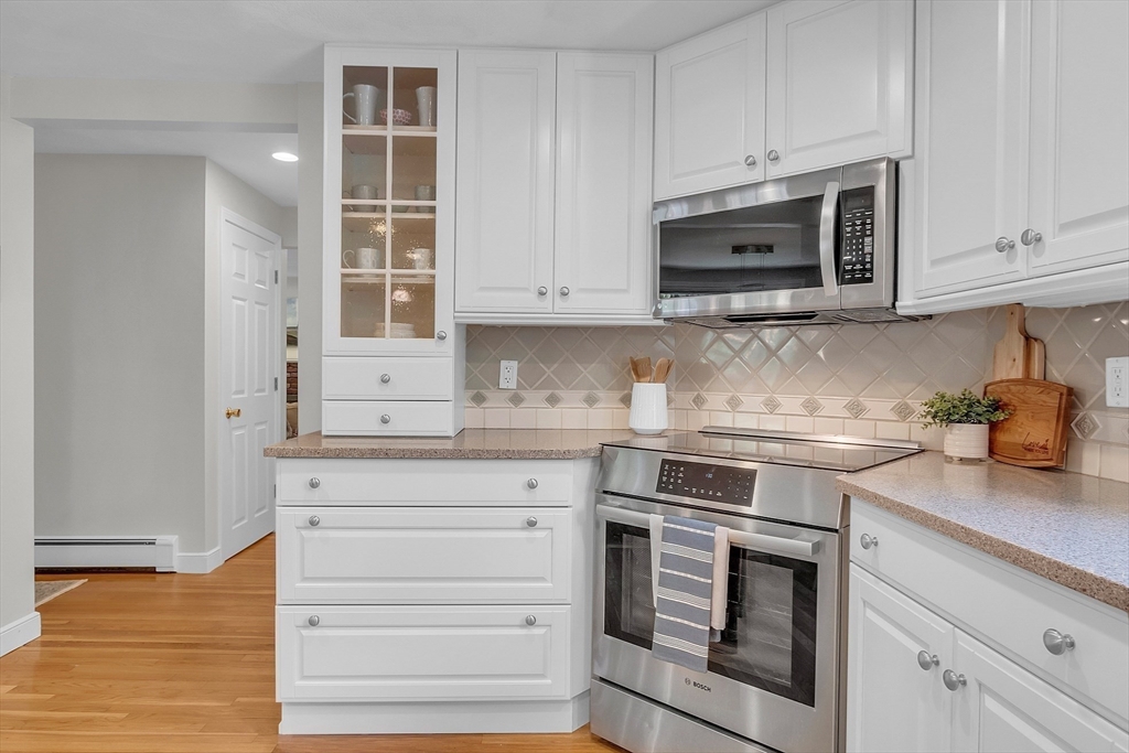 9 Berry Lane Acton, MA 01720 - Photo 7 of 42 a kitchen with granite countertop white cabinets and stainless steel appliances