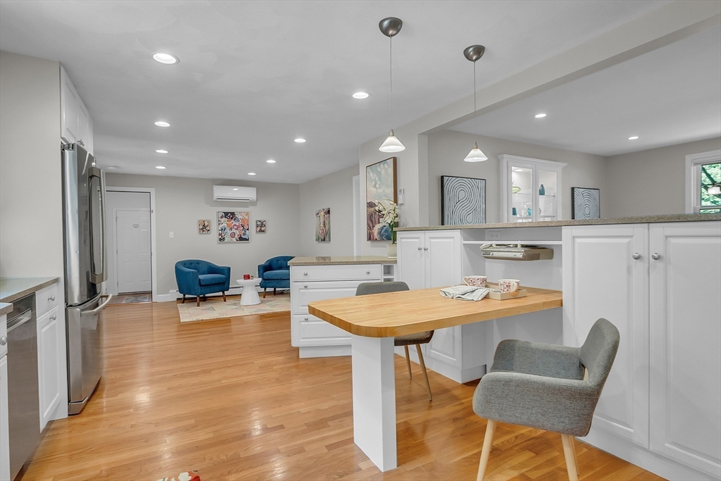 9 Berry Lane Acton, MA 01720 - Photo 8 of 42 a kitchen with stainless steel appliances kitchen island granite countertop a dining table chairs refrigerator and sink